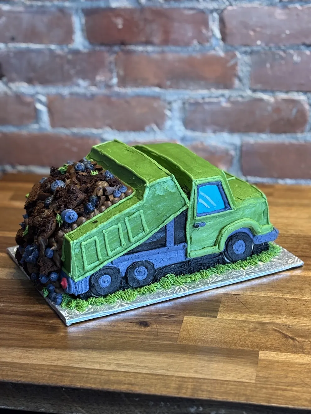 A dump truck cake hauling chocolate cookie crumbs